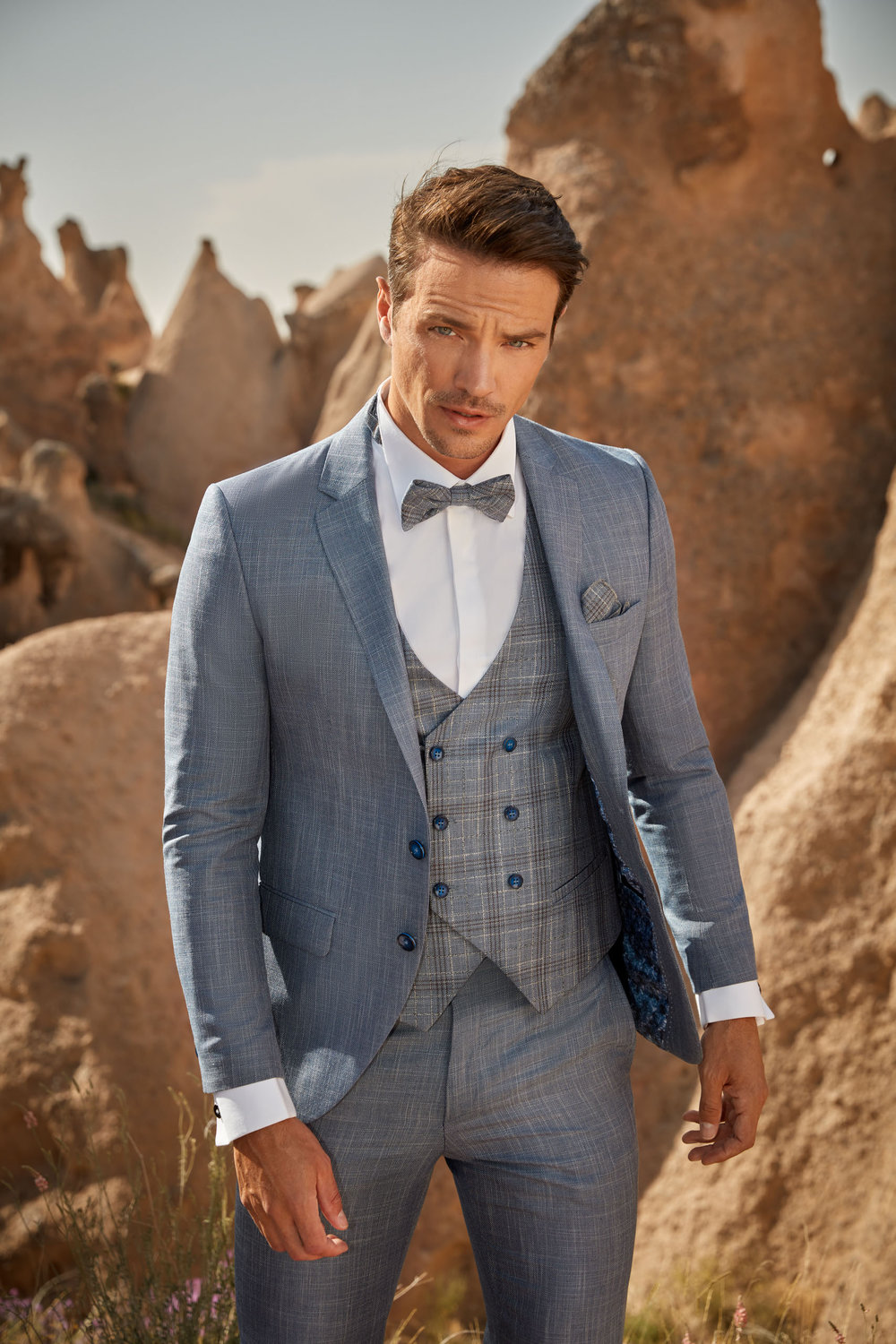 Detailansicht vom blauen Anzug mit Karomuster, Fliege und doppelreihiger Weste