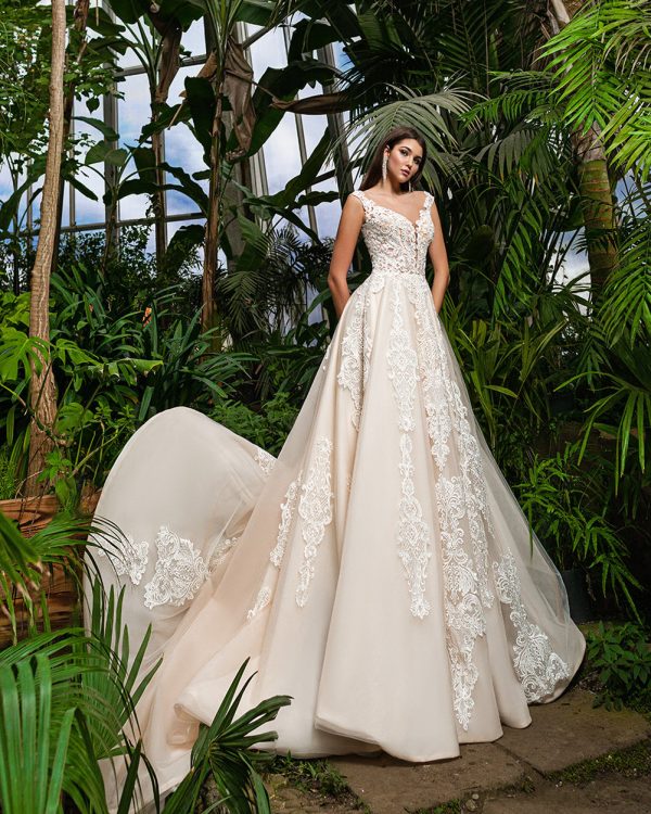 Braut in einem eleganten Prinzessin-Brautkleid mit floralen Spitzenapplikationen, fotografiert in einem tropischen Gewächshaus