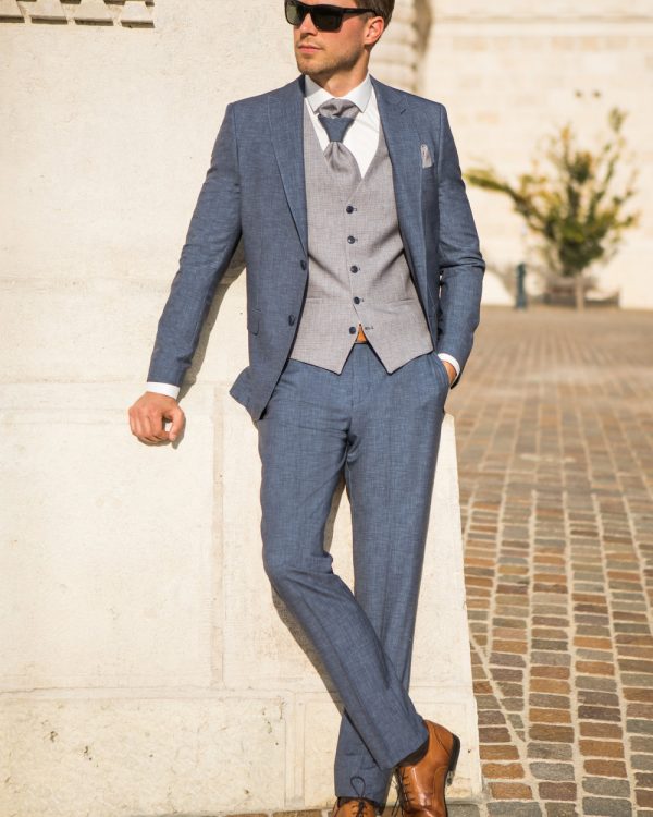 Moderner Bräutigamanzug in Hellblau mit grauer Weste, Krawatte und braunen Schuhen – stilvoller Look für die Sommerhochzeit im Freien.