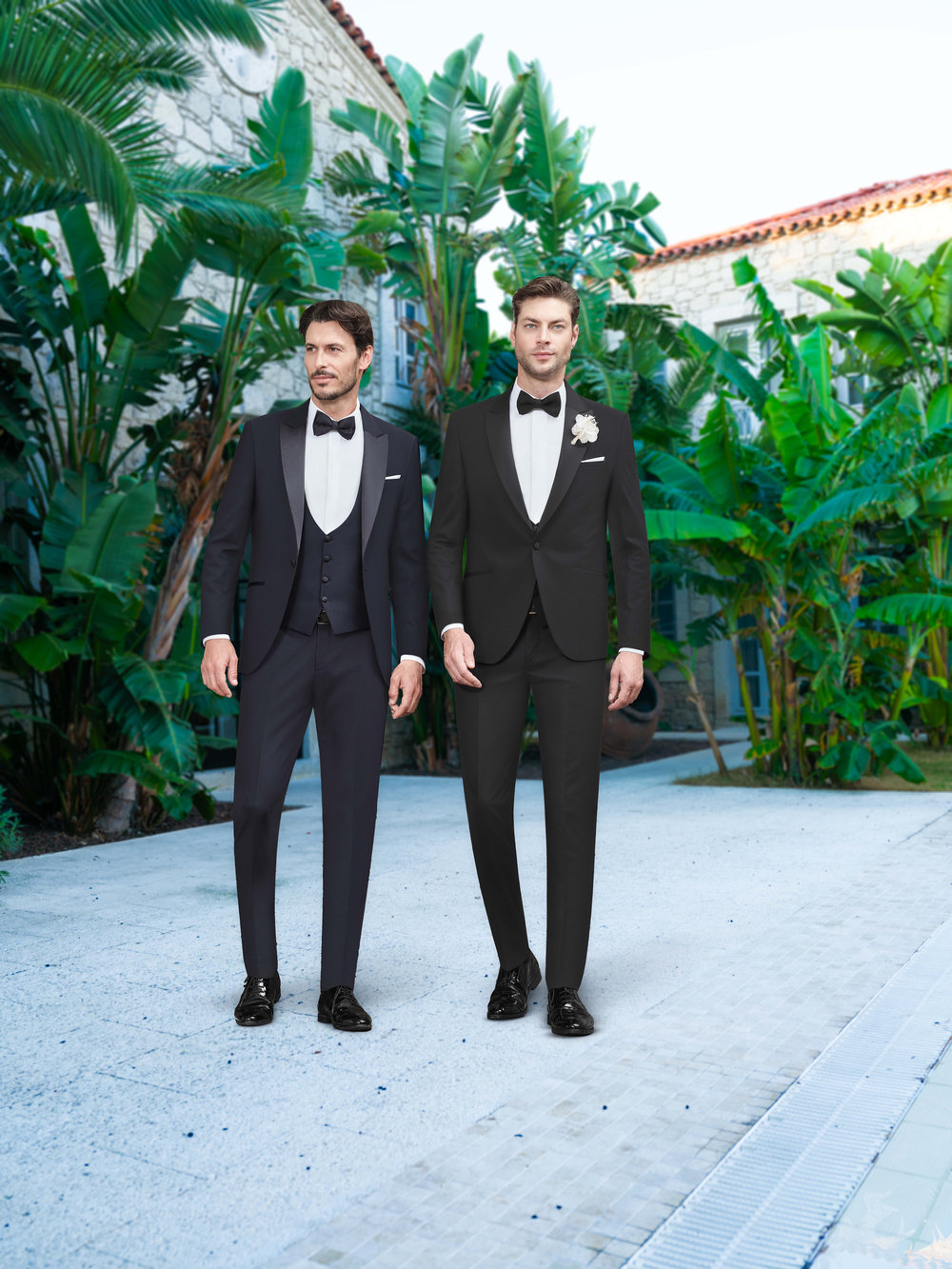 Klassischer Smoking in Schwarz und Dunkelblau für den Bräutigam – stilvoller Hochzeitslook mit Fliege in eleganter mediterraner Kulisse.