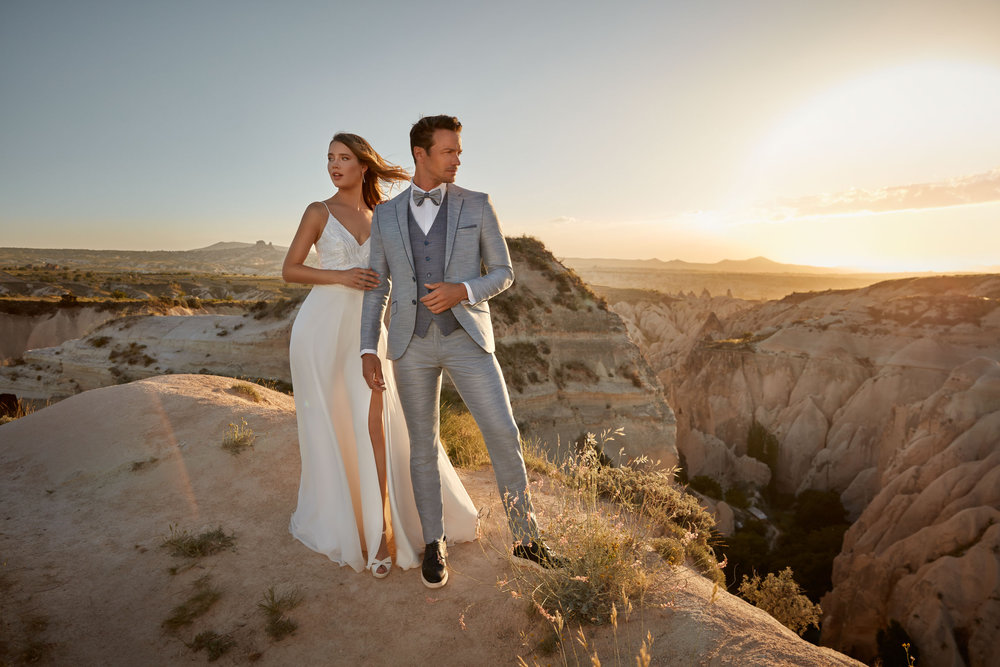 Blauer Hochzeitsanzug mit Weste und Fliege – eleganter Bräutigamlook in harmonischer Kombination mit einem weißen Brautkleid.