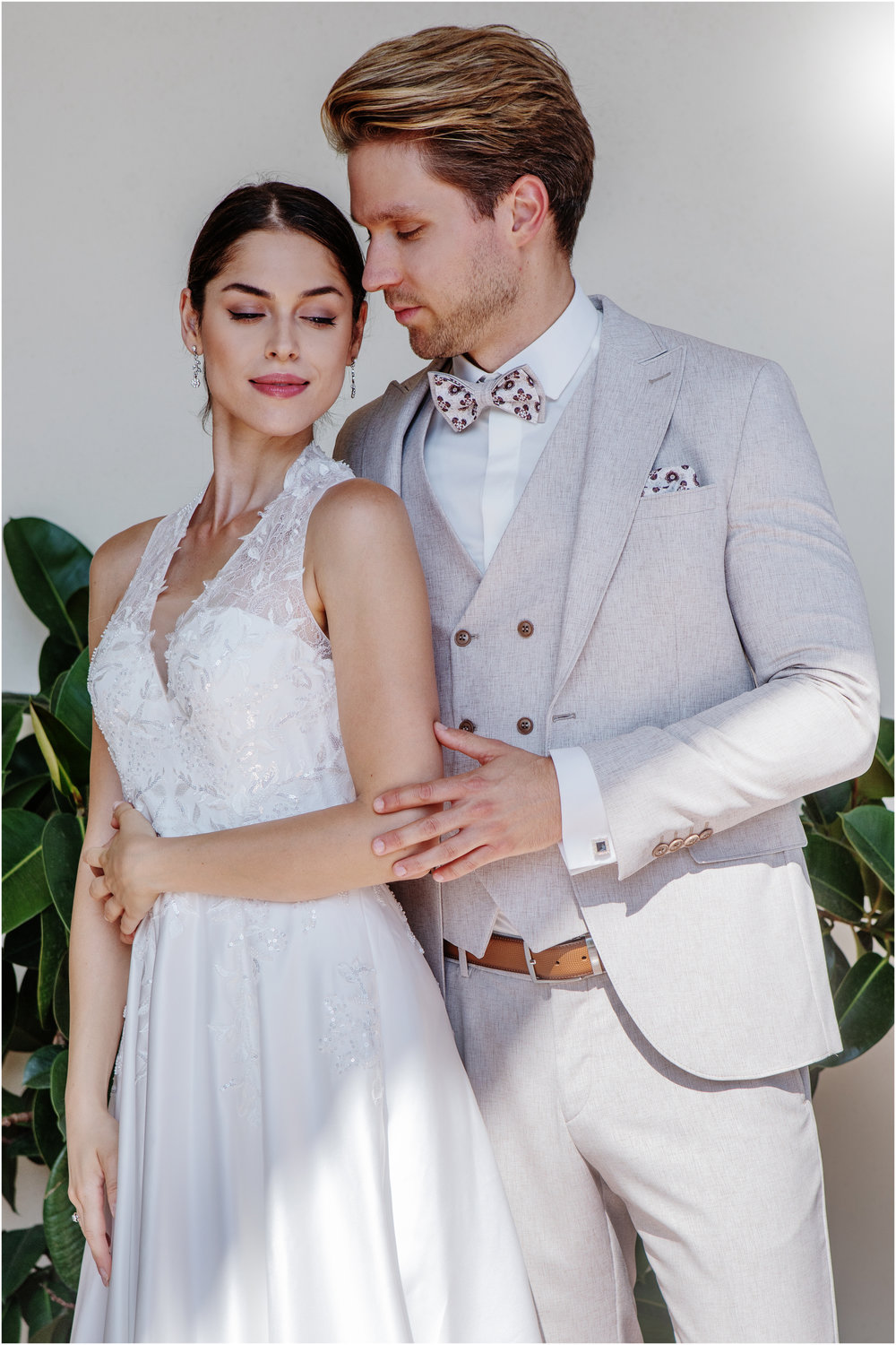 Moderner Hochzeitsanzug in Beige mit Weste und gemusterter Fliege – edler Bräutigam-Look gemeinsam mit Braut im weißen Kleid.