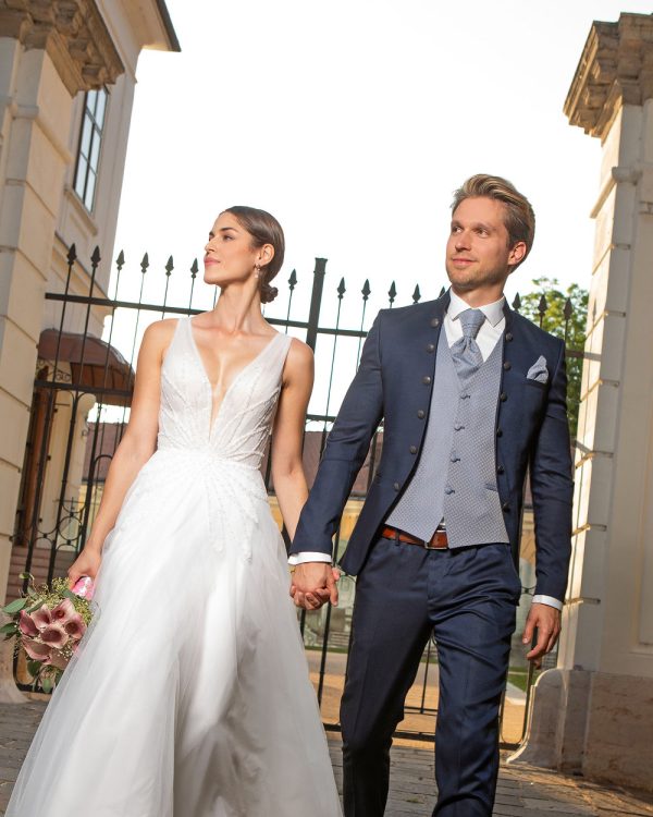 Dunkelblauer Bräutigamanzug mit Stehkragen, hellblauer Weste und Krawatte – eleganter Hochzeitslook im harmonischen Paarstil.