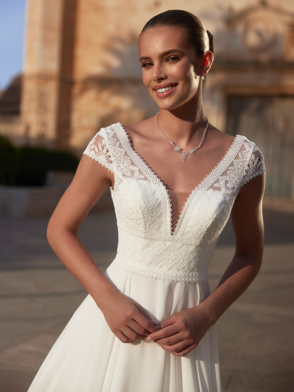 Detailaufnahme des Brautkleides mit tiefem V-Ausschnitt und feiner Boho-Spitze am Oberteil