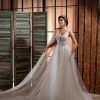 Elegantes Prinzessin-Brautkleid mit tiefem Ausschnitt und glitzerndem Tüllrock, fotografiert in rustikalem Innenraum mit Vintage-Holzelementen.