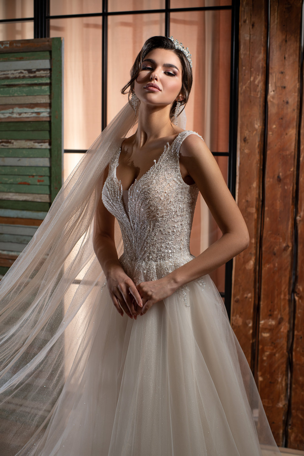 Detailaufnahme der funkelnden Corsage mit transparenten Trägern und tiefem V-Ausschnitt, verziert mit Glitzer und feiner Spitze.