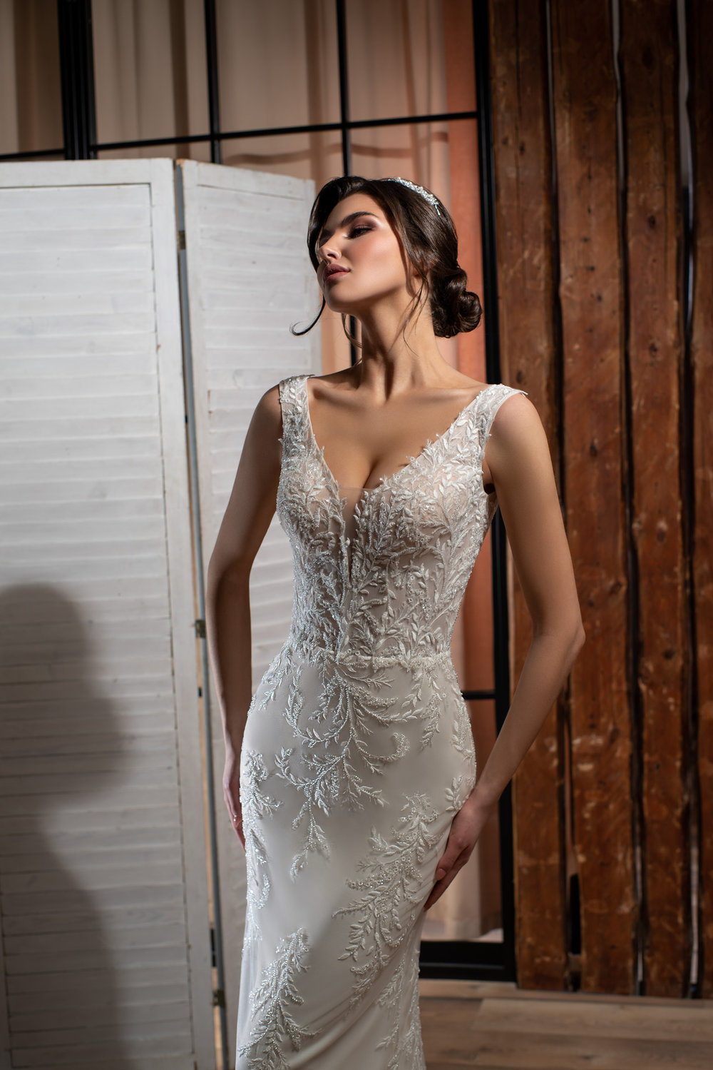 Detailansicht des tiefen V-Ausschnitts mit funkelnden Pailletten, fein gearbeiteter Spitze und transparenten Trägern im Fit & Flare Stil.