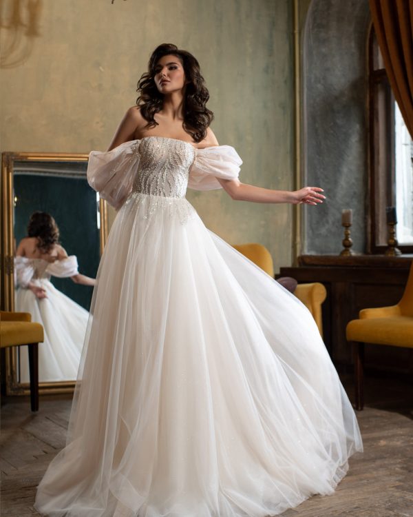 Prinzessin Brautkleid mit glitzerndem Tüllrock, herzförmigem Ausschnitt und abnehmbaren Puffärmeln – aufgenommen in luxuriösem Vintage-Ambiente mit Spiegel.