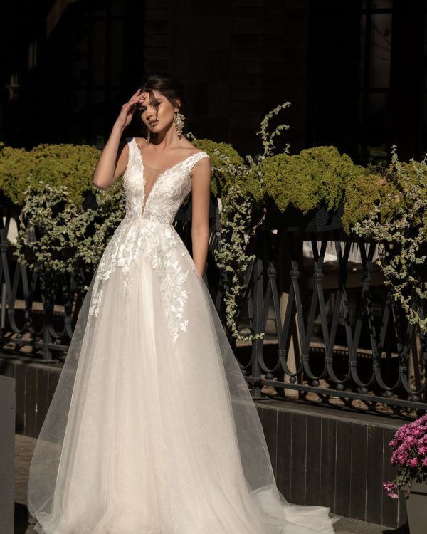 A-Linie Brautkleid mit tiefem Rückenausschnitt und zartem Tüllrock, Nahaufnahme von vorne, mit transparenten Trägern, Reißverschluss im Rücken und floral besticktem Oberteil.