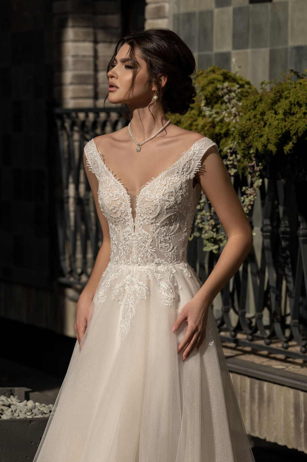 Elegantes A-Linie Brautkleid mit tiefem V-Ausschnitt und zarter Spitze, fotografiert von vorne – ideal für romantische Hochzeiten im modernen Stil.