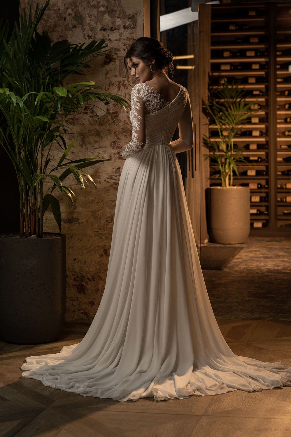 Rückenansicht Brautkleid mit Spitze, asymmetrischer Schulterführung und fließendem Rock aus Chiffon