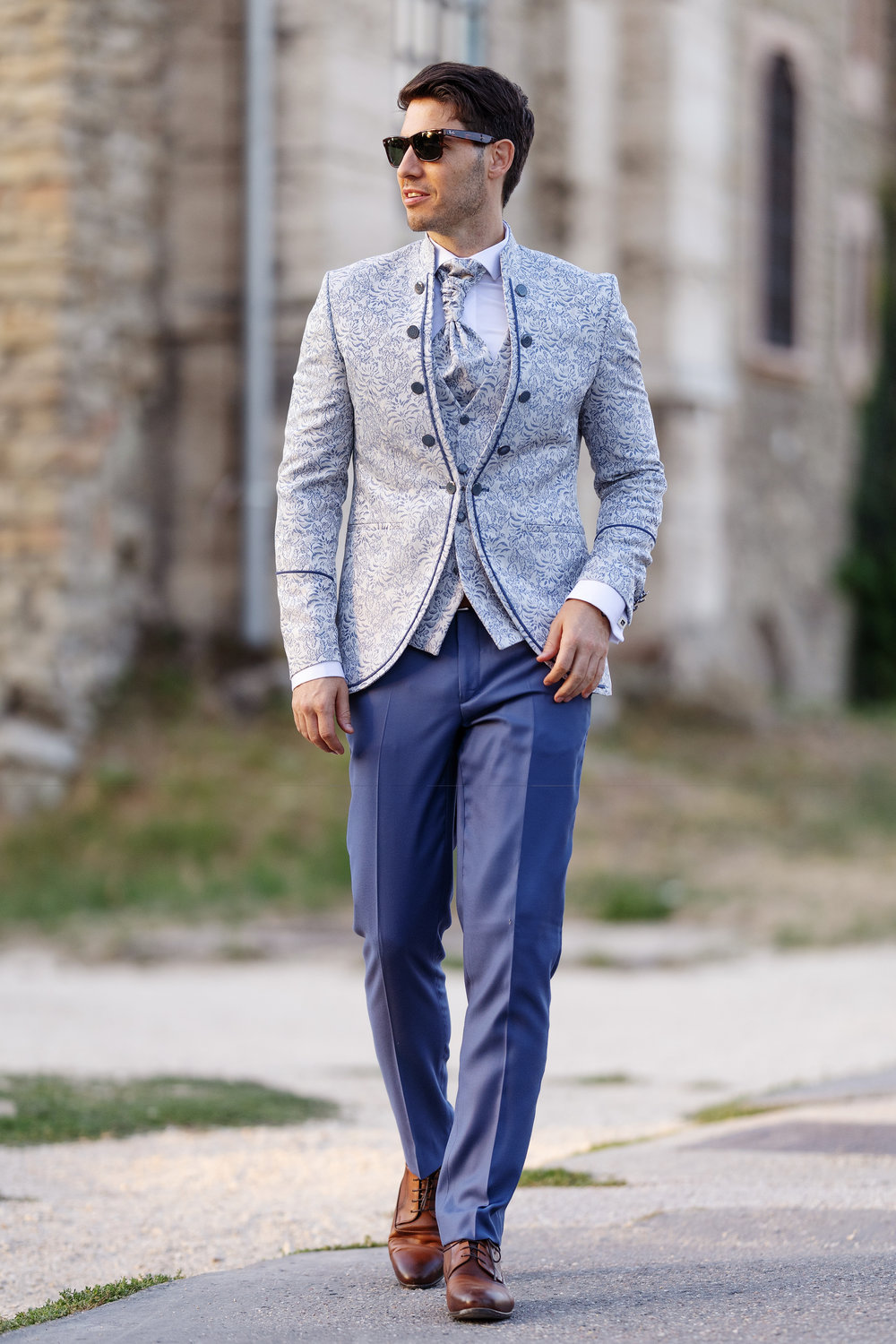 Extravagantes Bräutigam-Outfit in Hellblau mit floral gemustertem Sakko, Weste und Plastron – stilvoller Hochzeitslook mit modernem Twist.