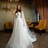 Elegantes Prinzessin Brautkleid mit fließendem Rock, transparenter Corsage und romantischen Cape-Ärmeln – fotografiert in einem stilvollen Vintage-Ambiente mit Kronleuchter.