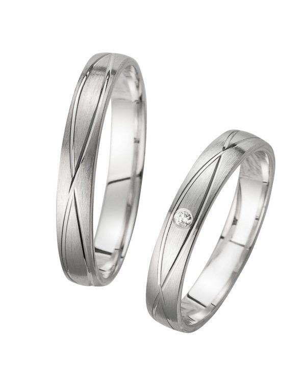 Trauringe mit geschwungener Rillenstruktur und Diamant im Damenring – modern und elegant