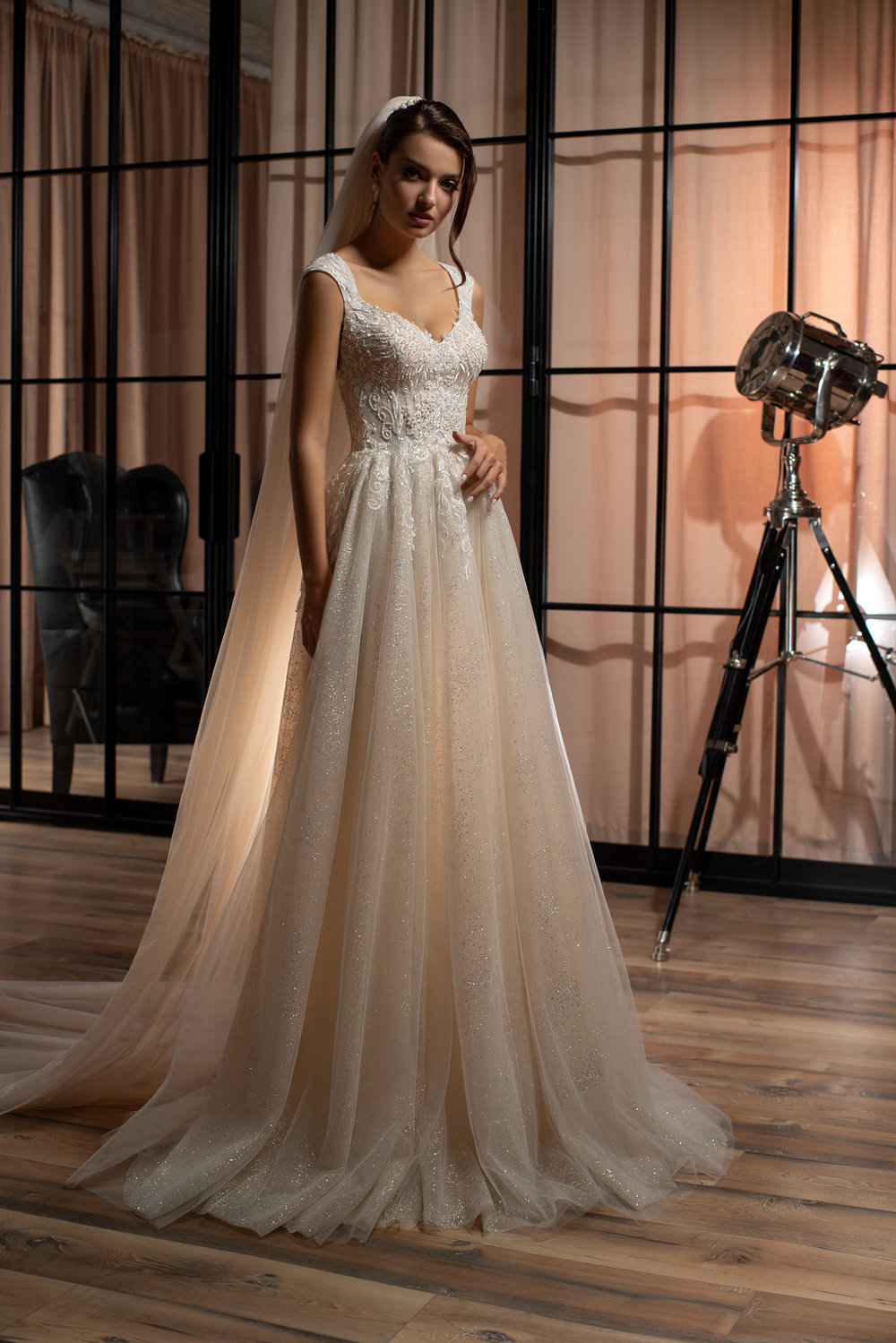 Aufnahme des bestickten V-Ausschnitt-Oberteils mit filigraner Spitze und transparenten Trägern – modernes Prinzessinnenkleid für stilbewusste Bräute.