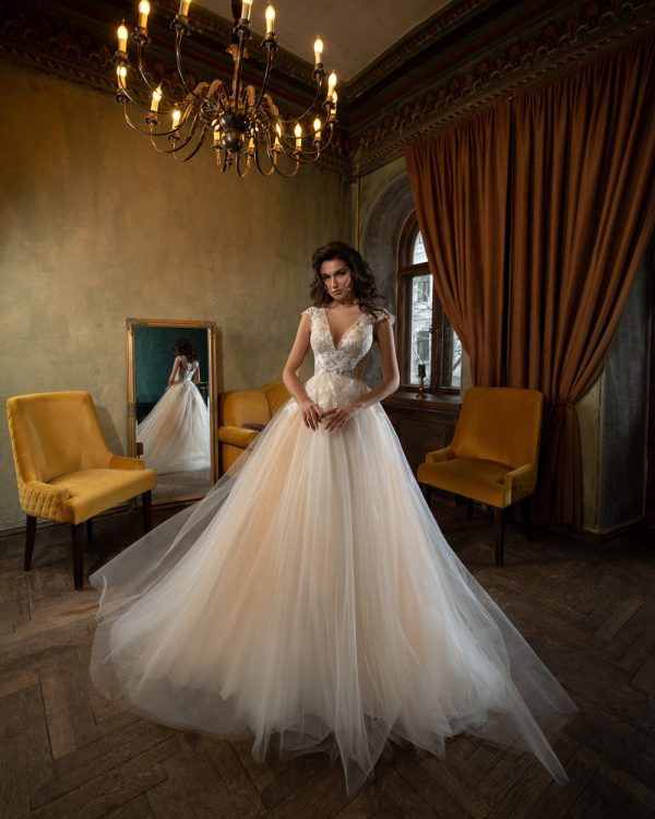 Elegantes Prinzessin Brautkleid mit tiefem V-Ausschnitt und Tüllrock, aufgenommen in einem stilvollen Vintage-Interieur mit Spiegel-Reflexion.