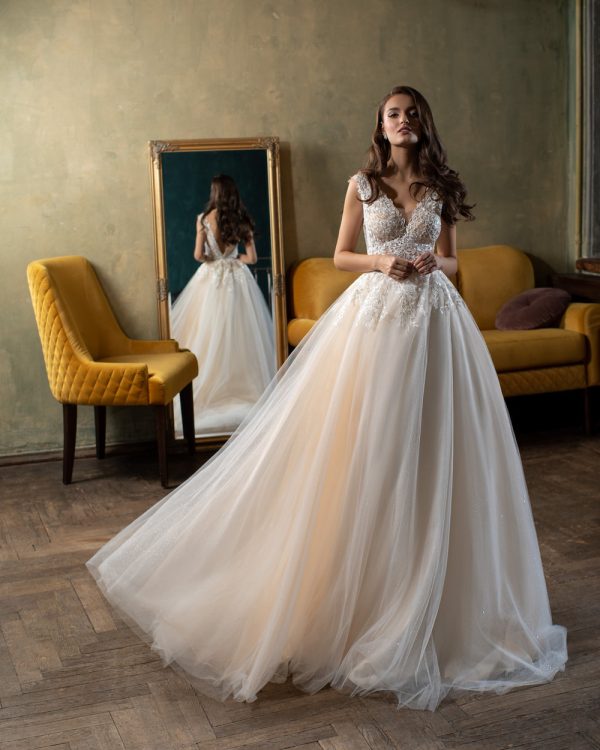 Romantisches Prinzessin Brautkleid mit Spitzencorsage und weit schwingendem Tüllrock – elegante Aufnahme im Vintage-Interieur.