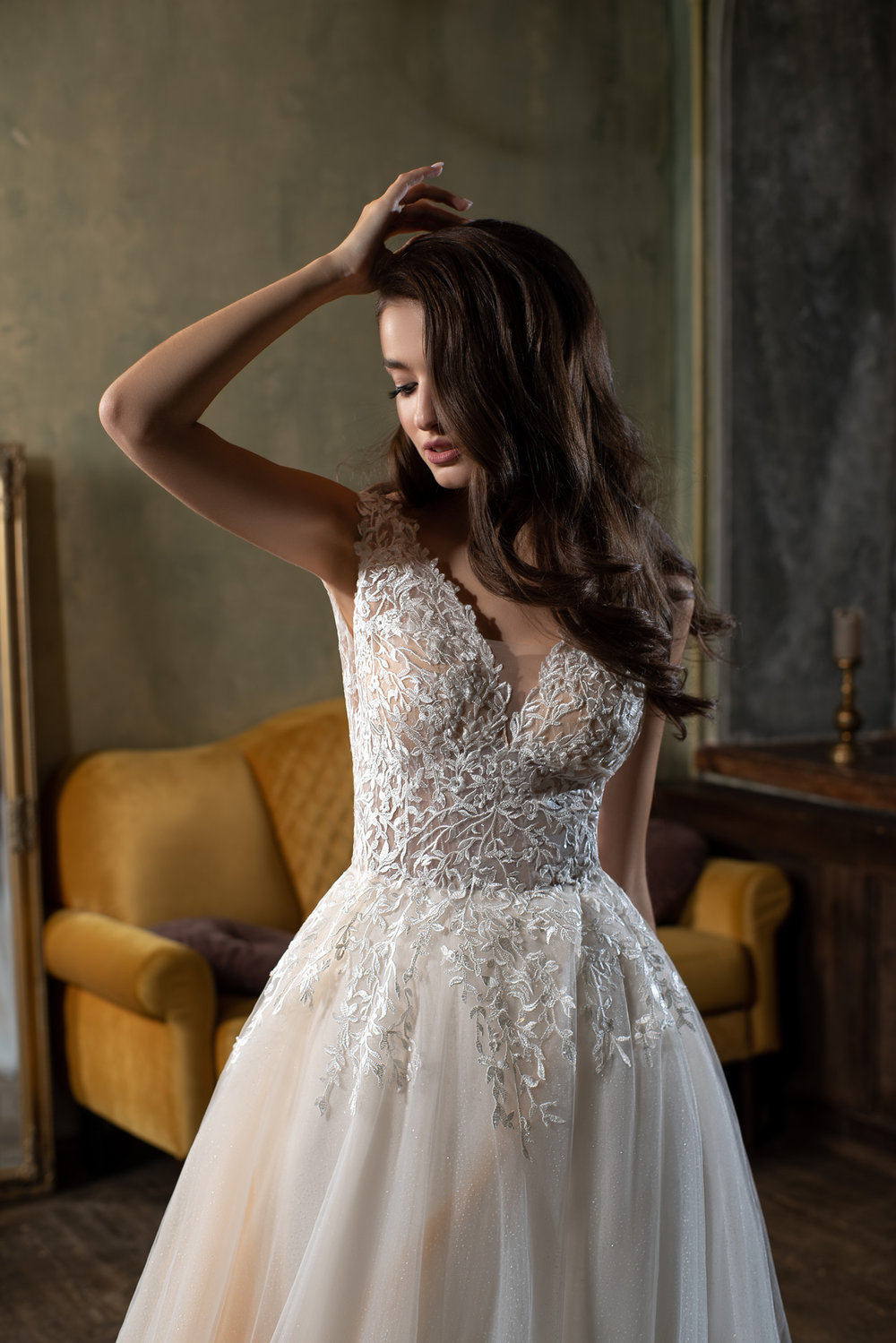 Nahaufnahme eines Prinzessin Brautkleides mit tiefem V-Ausschnitt, floraler Spitze und transparenten Trägern.