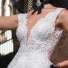 Schmales Fit & Flare Hochzeitskleid mit tiefem V-Ausschnitt, filigraner Spitze und figurbetontem Schnitt – moderner Glamour-Look für urbane Braut.