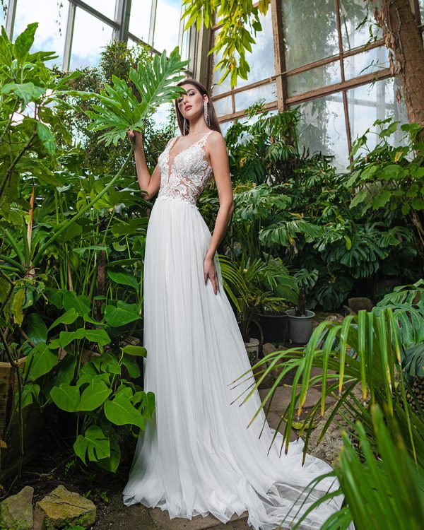 A-Linie Brautkleid mit floraler Spitze und fließendem Tüllrock, aufgenommen in einem tropischen Gewächshaus.