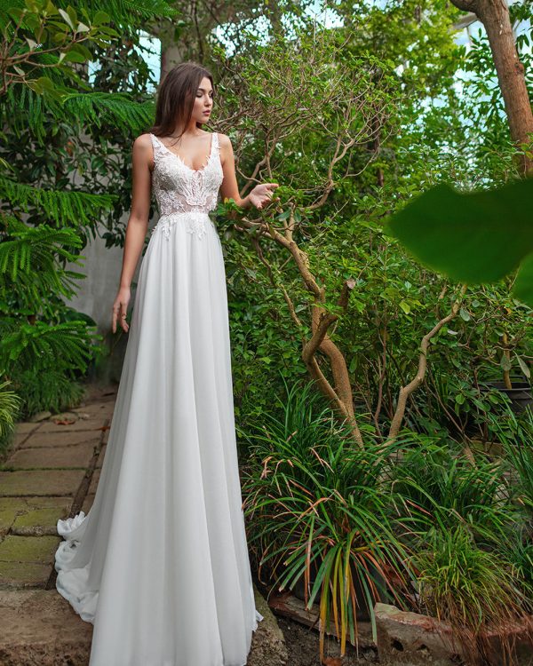 A-Linie Brautkleid mit Spitzenoberteil und fließendem Rock, in tropischer Kulisse aufgenommen.