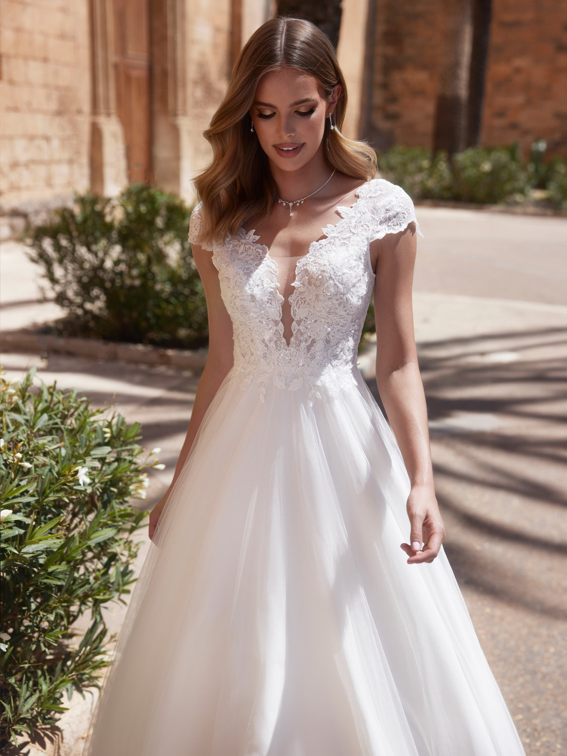 Detailansicht des Spitzenmieders mit tiefem V-Ausschnitt, floralen Applikationen und transparentem Tüll-Einsatz am Dekolleté.