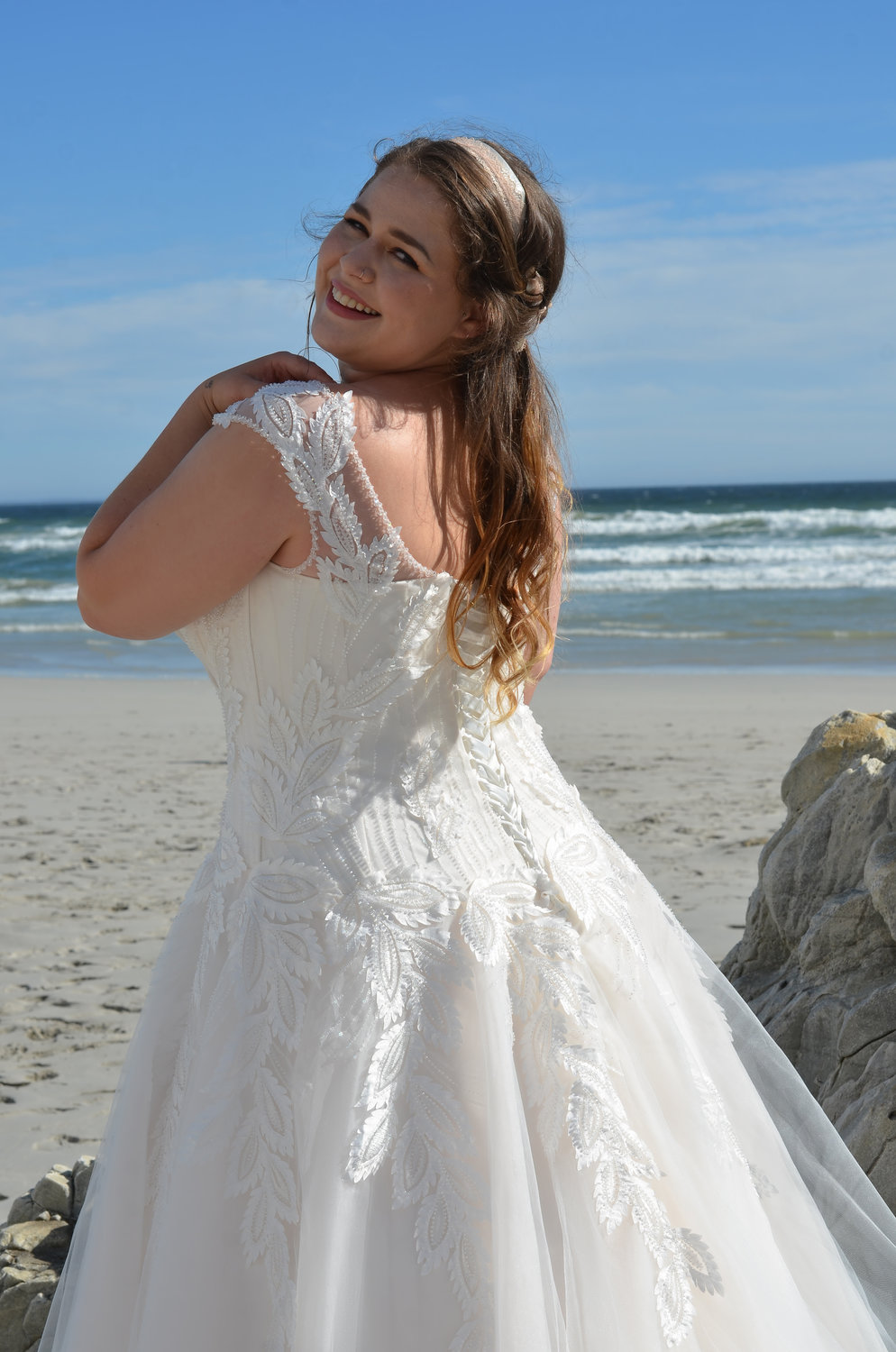 Detailaufnahme des Plus Size Brautkleids mit strukturiertem Spitzenmuster, breiten Trägern und Rückenschnürrung