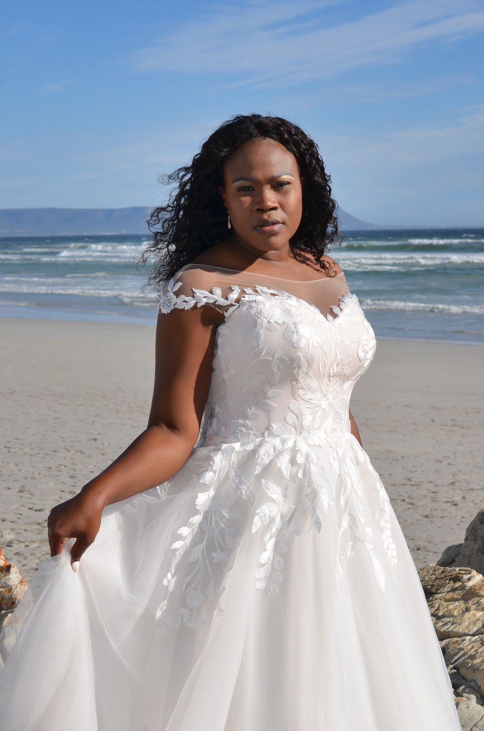 Detailaufnahme des Oberteils mit schulterfreiem Carmen-Ausschnitt, zarter floraler Spitze und herzförmigem Dekolleté.